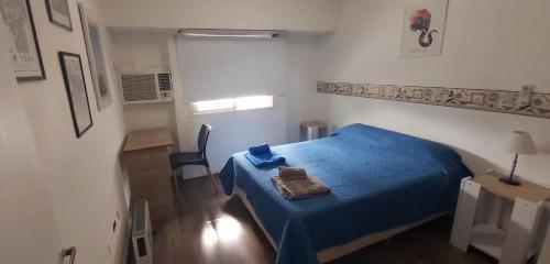 una piccola camera con letto blu e sedia di Hermoso depto céntrico! a Corrientes