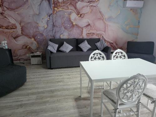a living room with a couch and a table and chairs at Casa Ratiu Apartamente 3 stele Airport Bucharest Therme Bucharest in Baloteşti