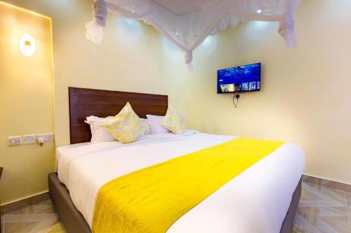 a bedroom with a large bed with a yellow blanket at Marrkson Suites Hotel in Nairobi