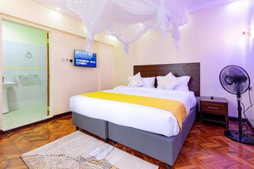 a bedroom with a large bed and a shower at Marrkson Suites Hotel in Nairobi