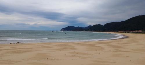 a beach with a group of people in the water at CASA Atzu Loft Argoños in Argoños