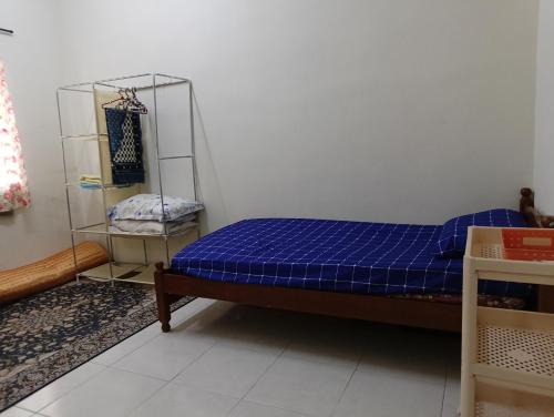 a small bedroom with a bed and a shelf at Homestay Kak Ninie in Teluk Intan