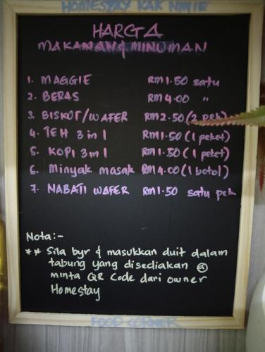 a chalkboard with writing on a black board at Homestay Kak Ninie in Teluk Intan