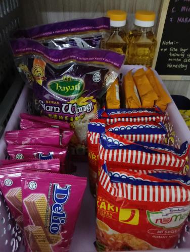 a shelf with several bags of chips and other snacks at Homestay Kak Ninie in Teluk Intan