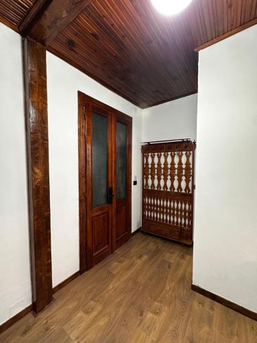 an empty room with a wooden door and wooden floors at Antique House Muradie in Vlorë