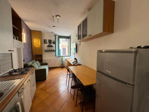 a kitchen with a refrigerator and a table in it at Centro Storico - Antica Via in Ferrara