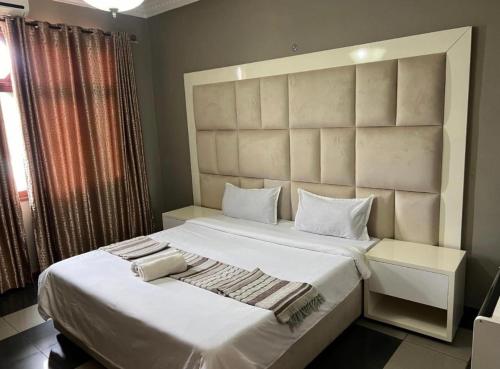 a bedroom with a large white bed and a window at TR CASA DE AcCOMODAÇÃO in Matola