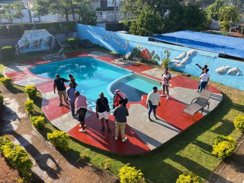 a group of people standing around a swimming pool at TR CASA DE AcCOMODAÇÃO in Matola