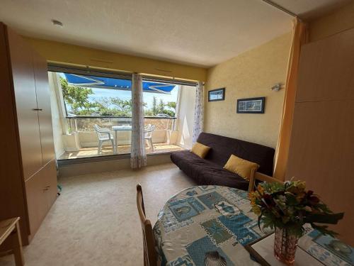un petit salon avec une table et un canapé dans l'établissement Studio rénové, 50m plage, terrasse sud, parking privé, 4 couchages, Saint-Jean-de-Monts - FR-1-224C-82, à Saint-Jean-de-Monts