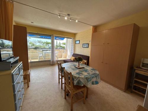 une salle à manger avec une table et des chaises et une cuisine dans l'établissement Studio rénové, 50m plage, terrasse sud, parking privé, 4 couchages, Saint-Jean-de-Monts - FR-1-224C-82, à Saint-Jean-de-Monts