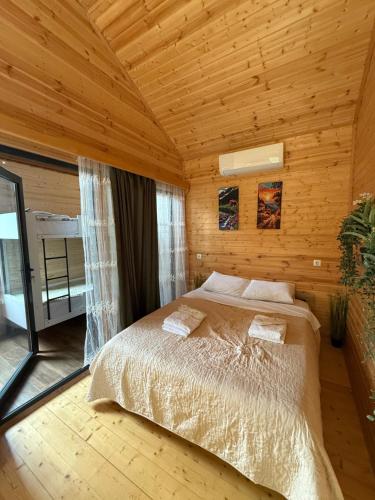 ein Schlafzimmer mit einem Bett in einem Holzzimmer in der Unterkunft Orion Palace in Batumi