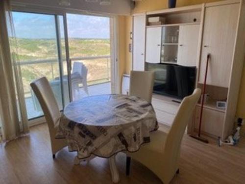 a dining room table and chairs in a room with a kitchen at Appartement en bord de mer pour 4 pers avec balcon, parking et animaux admis - FR-1-236-169 in Cucq