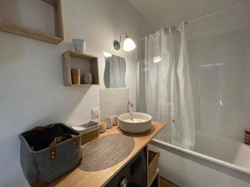 une salle de bain avec un lavabo et une baignoire dans l'établissement Studio rénové 2* à 50m de la plage avec balcon - 4 couchages - FR-1-224C-216, à Saint-Jean-de-Monts