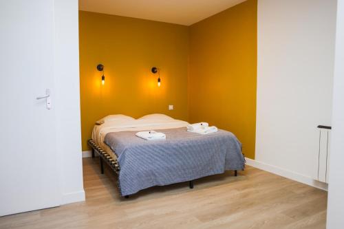 a bedroom with a bed with two towels on it at L'immeuble Carnot in Tournus
