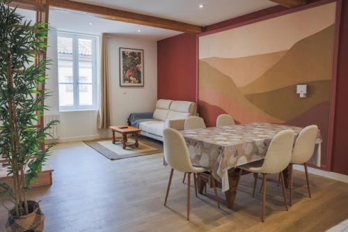 a living room with a table and chairs and a couch at L'immeuble Carnot in Tournus