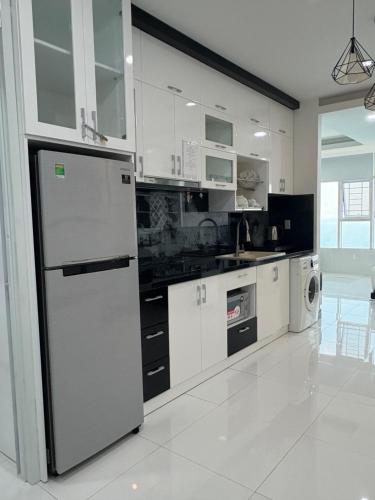 a kitchen with white cabinets and a refrigerator at Muong Thanh Oceanfront Retreat apartment in Nha Trang