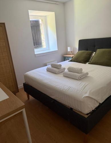 a bedroom with a large bed with towels on it at Les Platanes in Yvoire
