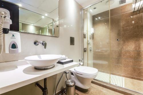 a bathroom with a toilet and a sink and a shower at Hotel Grand Godwin - Free Airport Pick-Up in New Delhi