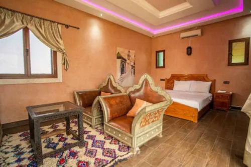 a bedroom with a bed and a couch and a table at 5-Bedroom Villa Guesthouse with Heated Pool in Tillouna