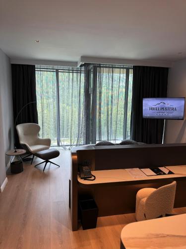 an office with a desk and a television in a room at Hotel Pestera Wellness & Spa in Sinaia