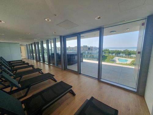 an empty gym with chairs and a large window at SzemesBay Apartment in Balatonszemes