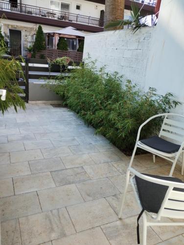 a patio with two chairs and a bench at Villa Olympia in Paralia Katerinis