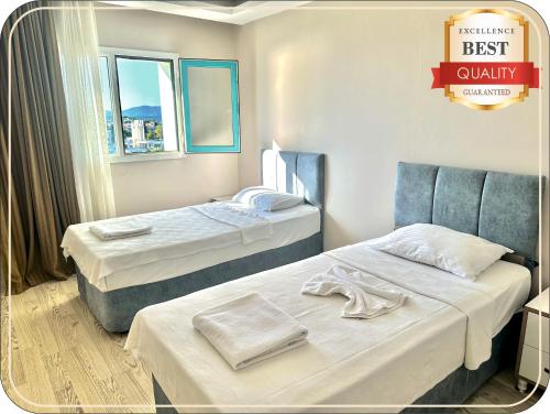 a hotel room with two beds and a best quality sign at Silver Tower Family Apart Otel in Kuşadası