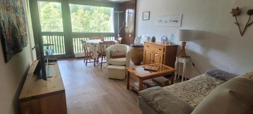 Grand studio près Lac Gaillands في شامونيه مون بلان: غرفة معيشة بها أريكة وطاولة