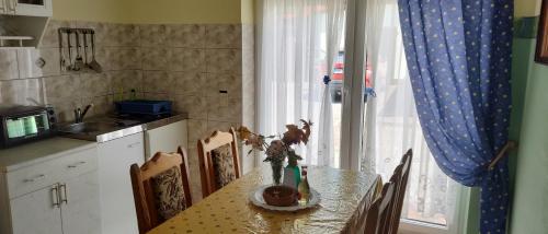 a kitchen table with a vase of flowers on it at Landpension Zum Schweizerberg in Neugrimnitz