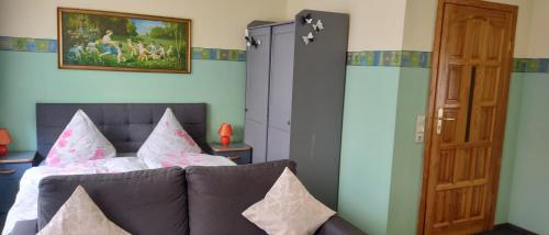 a bedroom with a couch and a painting on the wall at Landpension Zum Schweizerberg in Neugrimnitz