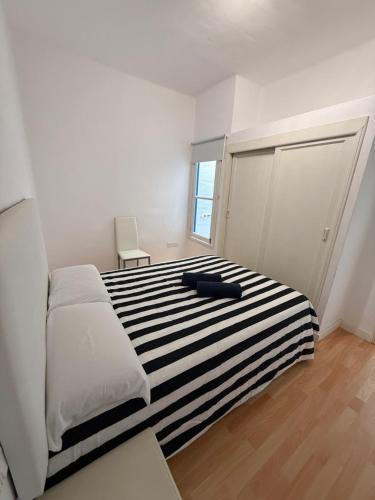 een slaapkamer met een bed met een zwart-wit gestreept tapijt bij bonito y acogedor apartamento in Famara