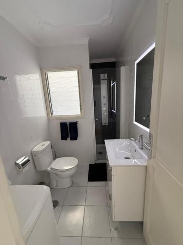 een witte badkamer met een toilet en een wastafel bij bonito y acogedor apartamento in Famara