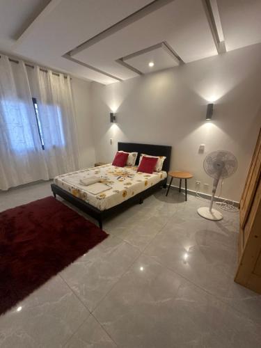 a bedroom with a bed and a table and a fan at Chambre Cosy à Dakar in Dakar