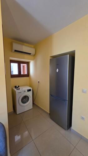 a kitchen with a refrigerator and a washing machine at JP Central Apartment in Chios