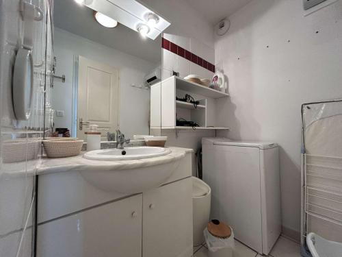 une salle de bain blanche avec un lavabo et des toilettes dans l'établissement Maison climatisée avec 2 pièces et mezzanine, 5 couchages, parking, St Pierre la Mer - FR-1-229D-159, à Fleury