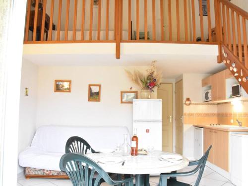 une cuisine et une salle à manger avec une table et des chaises dans l'établissement Maison T3 avec Mezzanine, Terrasse et Garage, à 1000m de la Plage - 6 couchages - FR-1-229D-67, à Fleury