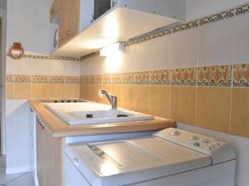 une petite cuisine avec un évier et une cuisinière dans l'établissement Maison T3 avec Mezzanine, Terrasse et Garage, à 1000m de la Plage - 6 couchages - FR-1-229D-67, à Fleury