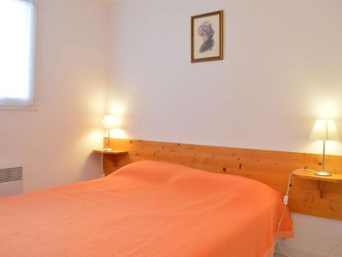 - une chambre avec un lit orange et deux lampes dans l'établissement Maison T3 avec Mezzanine, Terrasse et Garage, à 1000m de la Plage - 6 couchages - FR-1-229D-67, à Fleury