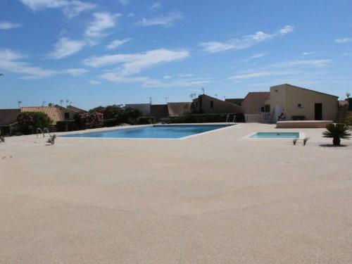 une grande piscine vide dans une cour dans l'établissement Maison studio mezzanine à Saint Pierre la Mer - FR-1-229D-157, à Fleury