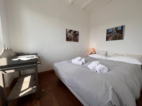 a white bedroom with a bed and a desk at Les Oliviers in Rapallo