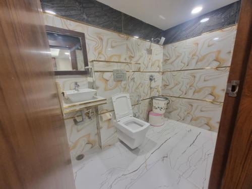 a bathroom with a toilet and a sink at Hotel Muskan in Mathura