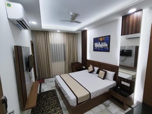 a hotel room with a bed and a tv at Hotel Muskan in Mathura