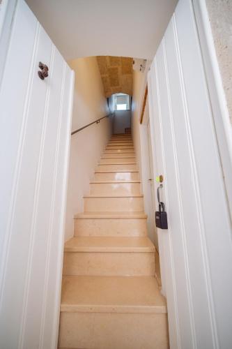 a staircase in a room with white doors at La Pupa coi baffi - Edificio Storico in Centro in Conversano