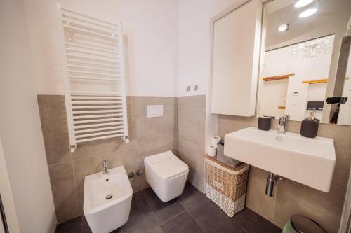 a bathroom with a white sink and a toilet at La Pupa coi baffi - Edificio Storico in Centro in Conversano