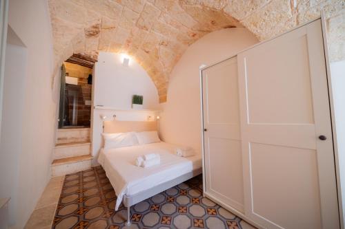 a small bedroom with a white bed in a room at La Pupa coi baffi - Edificio Storico in Centro in Conversano