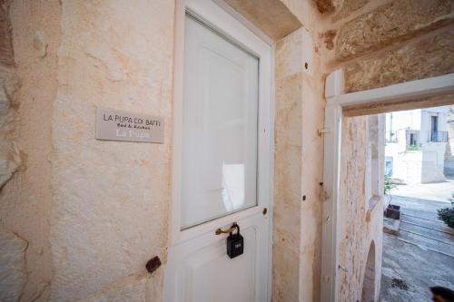 a white door in a room with a window at La Pupa coi baffi - Edificio Storico in Centro in Conversano