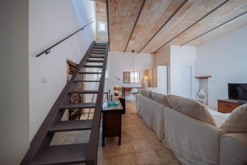a living room with a staircase and a couch at La Pupa coi baffi - Edificio Storico in Centro in Conversano