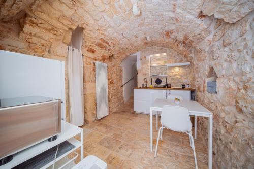 a living room with a white table and a tv at La Pupa coi baffi - Edificio Storico in Centro in Conversano