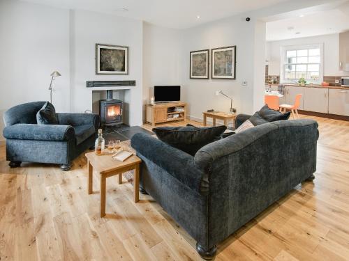 a living room with two couches and a fireplace at Willow in Gatehouse of Fleet