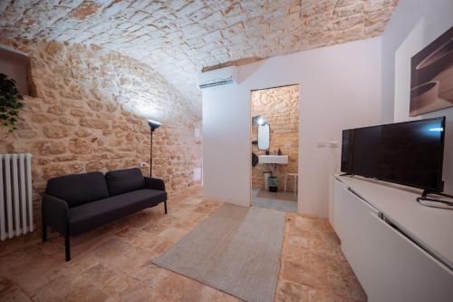 a living room with a couch and a flat screen tv at La Pupa coi baffi - Edificio Storico in Centro in Conversano